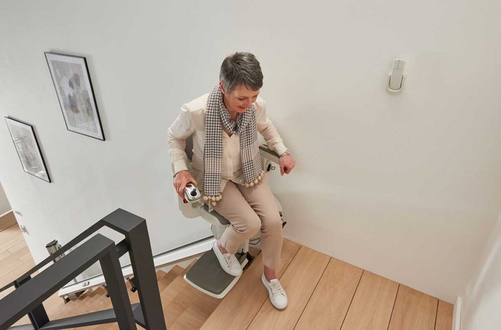 This is an image of a HomeGlide Extra Stairlift, which is designed to provide mobility assistance for people who have difficulty climbing stairs. The stairlift is made up of a comfortable seat and a track that attaches to the stairs. 